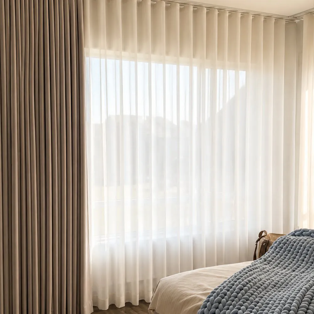 Sheer and blackout curtains layered in a bedroom