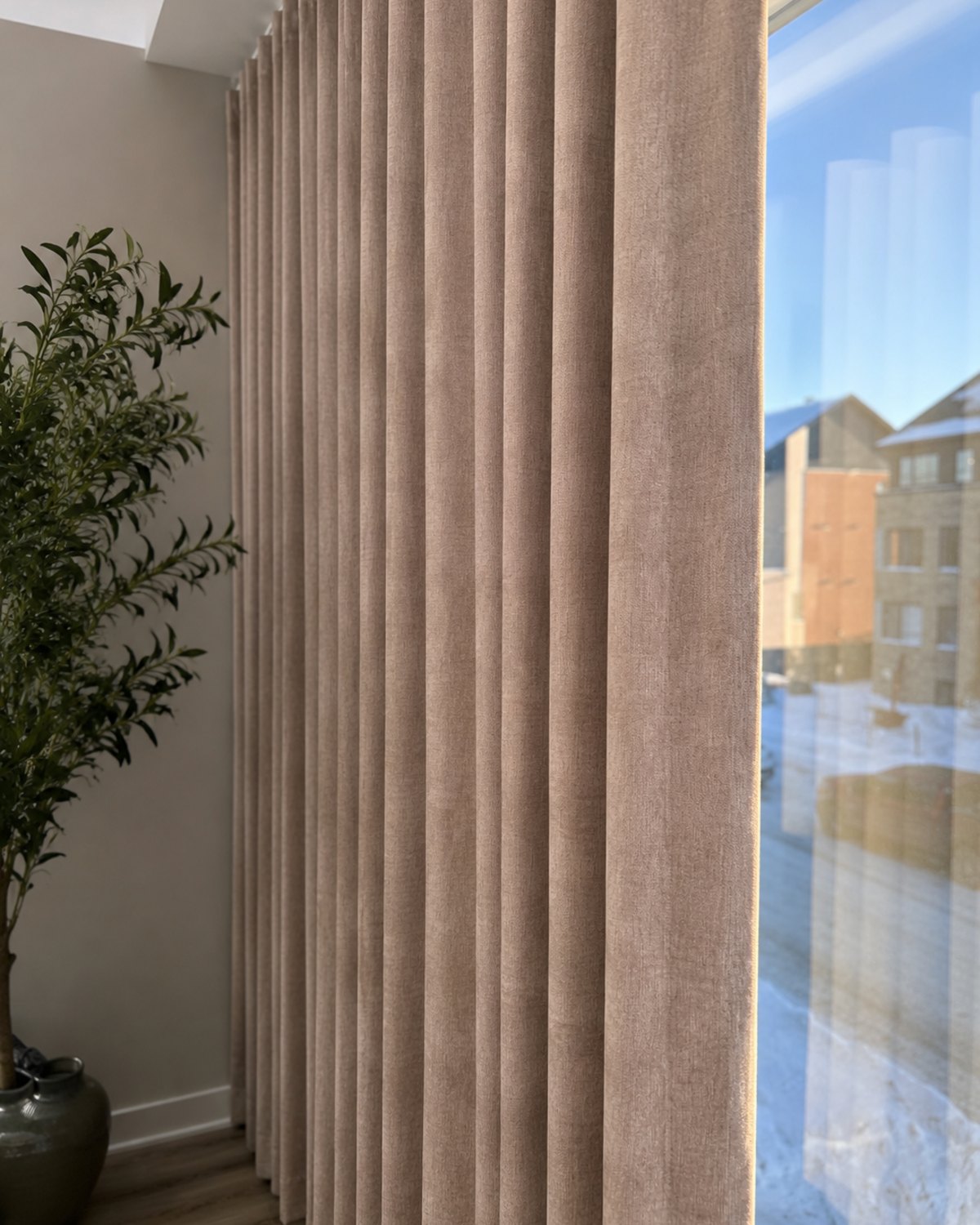 Blackout wave drapes beside a snowy Montreal window