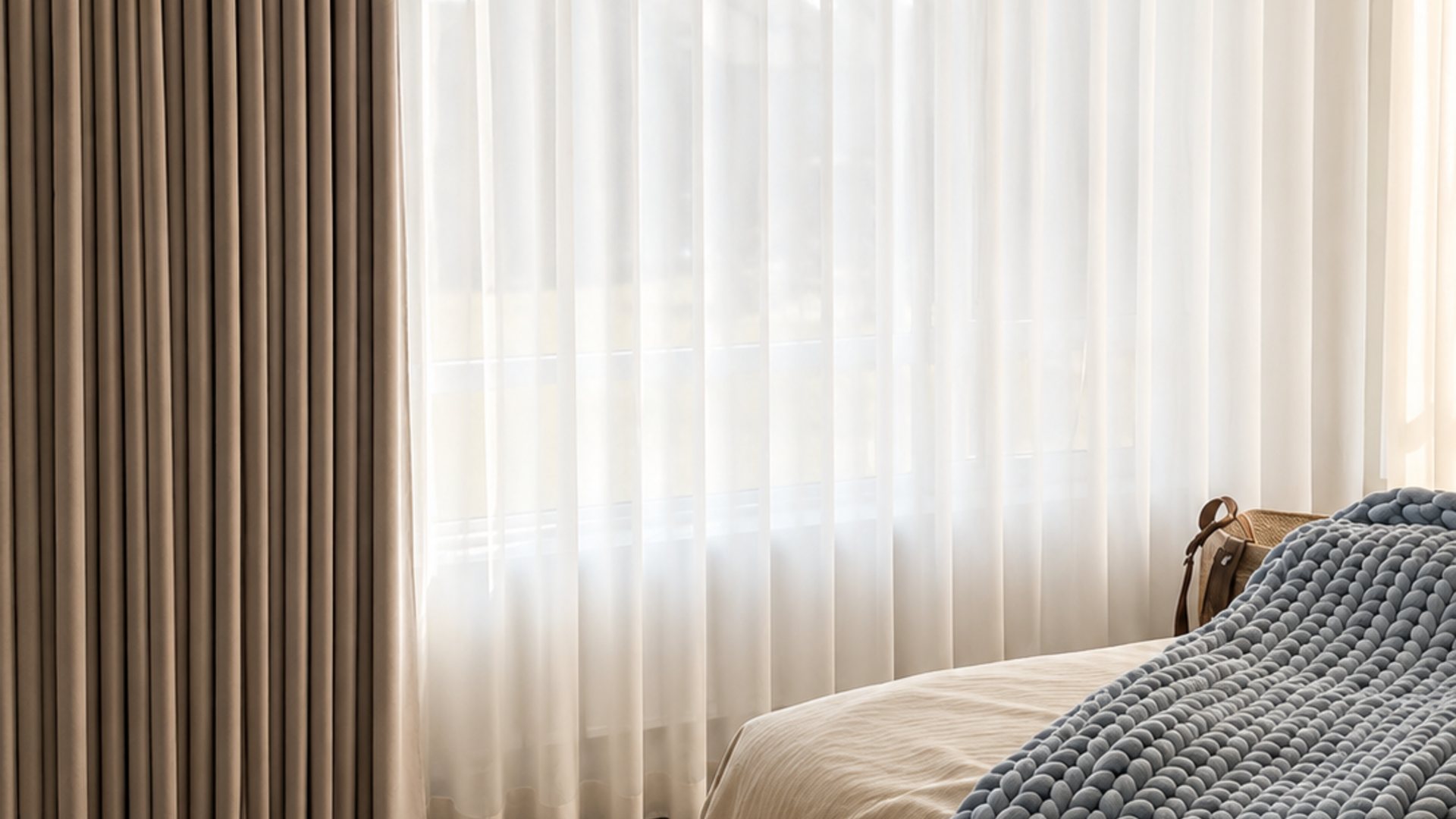 Sheer wave curtains layered with a blackout drape in a sunlit Montreal bedroom